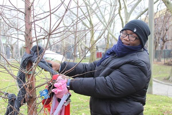 DLEACS' student ties scarf to a tree in Arlington Park.